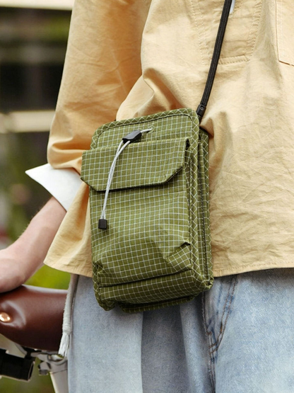 Organizer crossbody bag worn beside a bike — EDC crossbody in grid ripstop
