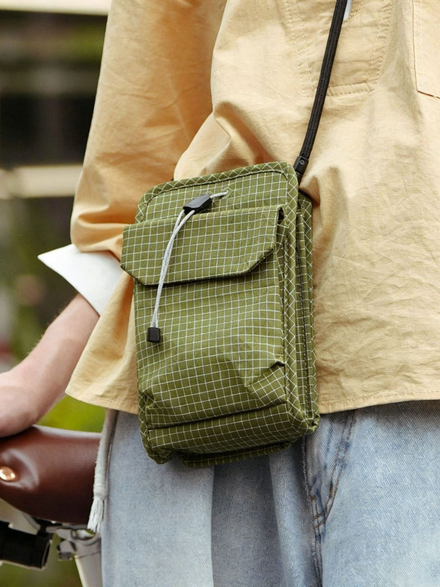 Organizer crossbody bag worn beside a bike — EDC crossbody in grid ripstop